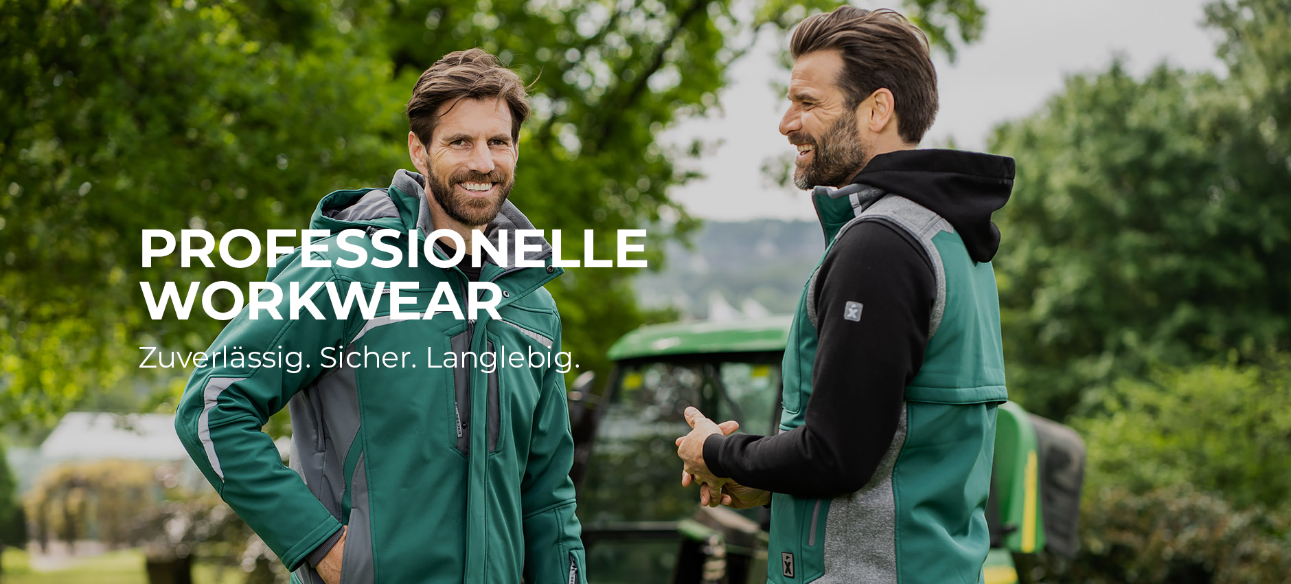 Zwei Männer in grüner Arbeitskleidung unterhalten sich im Freien vor einem grünen Traktor. Links im Bild steht der Text „Professionelle Workwear – Zuverlässig. Sicher. Langlebig.“