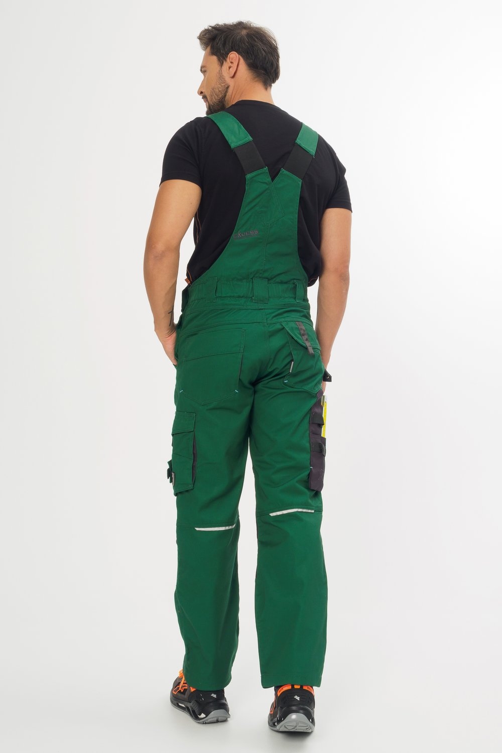 Rückansicht einer grünen Latzhose mit Brusttasche und praktischen Cargotaschen – robuste Arbeitslatzhose für Handwerker und Gartenbau.