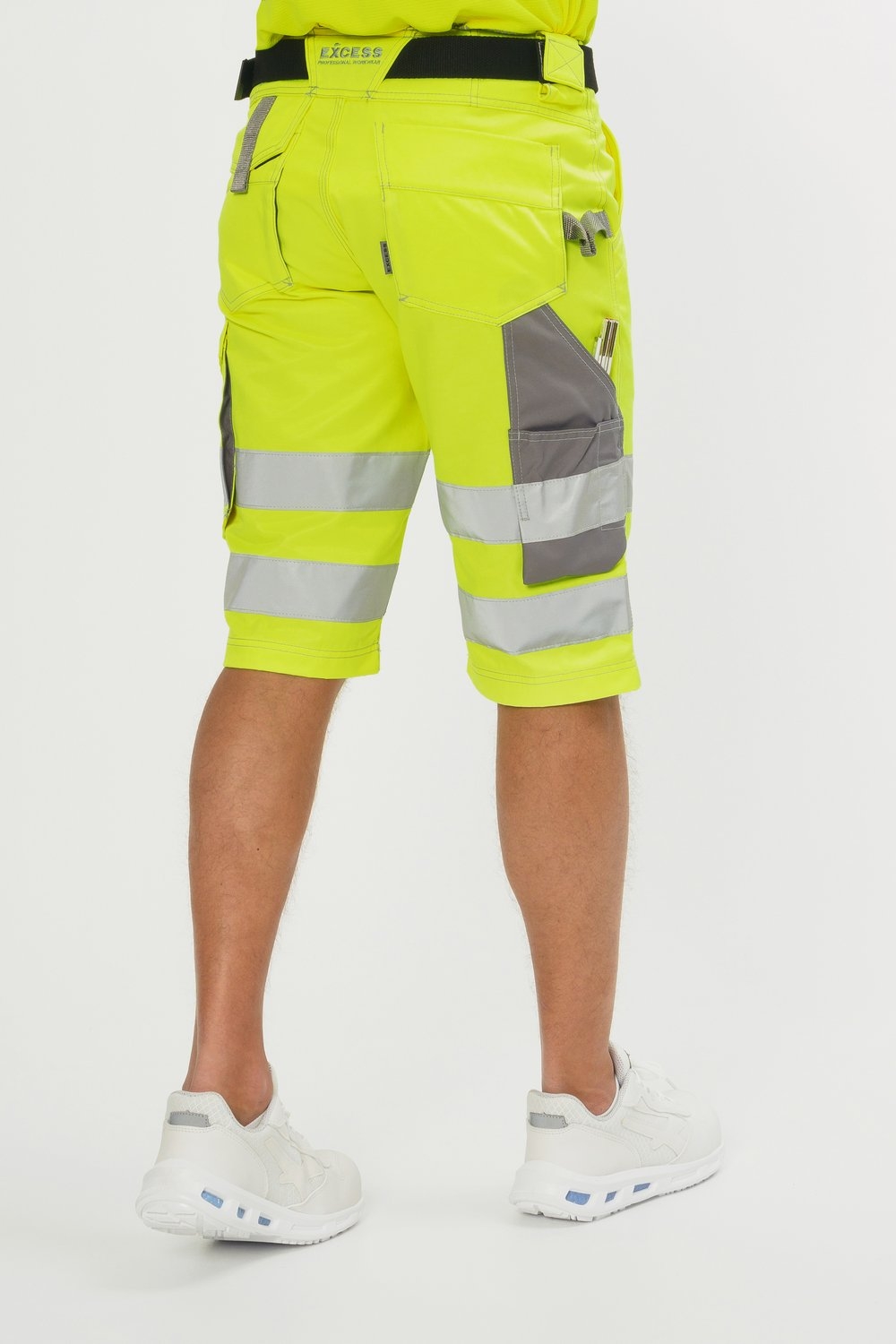 Rückansicht einer gelben Bermuda-Arbeitshose mit silbernen Reflexstreifen, Gürtelschlaufen und praktischen Seitentaschen.