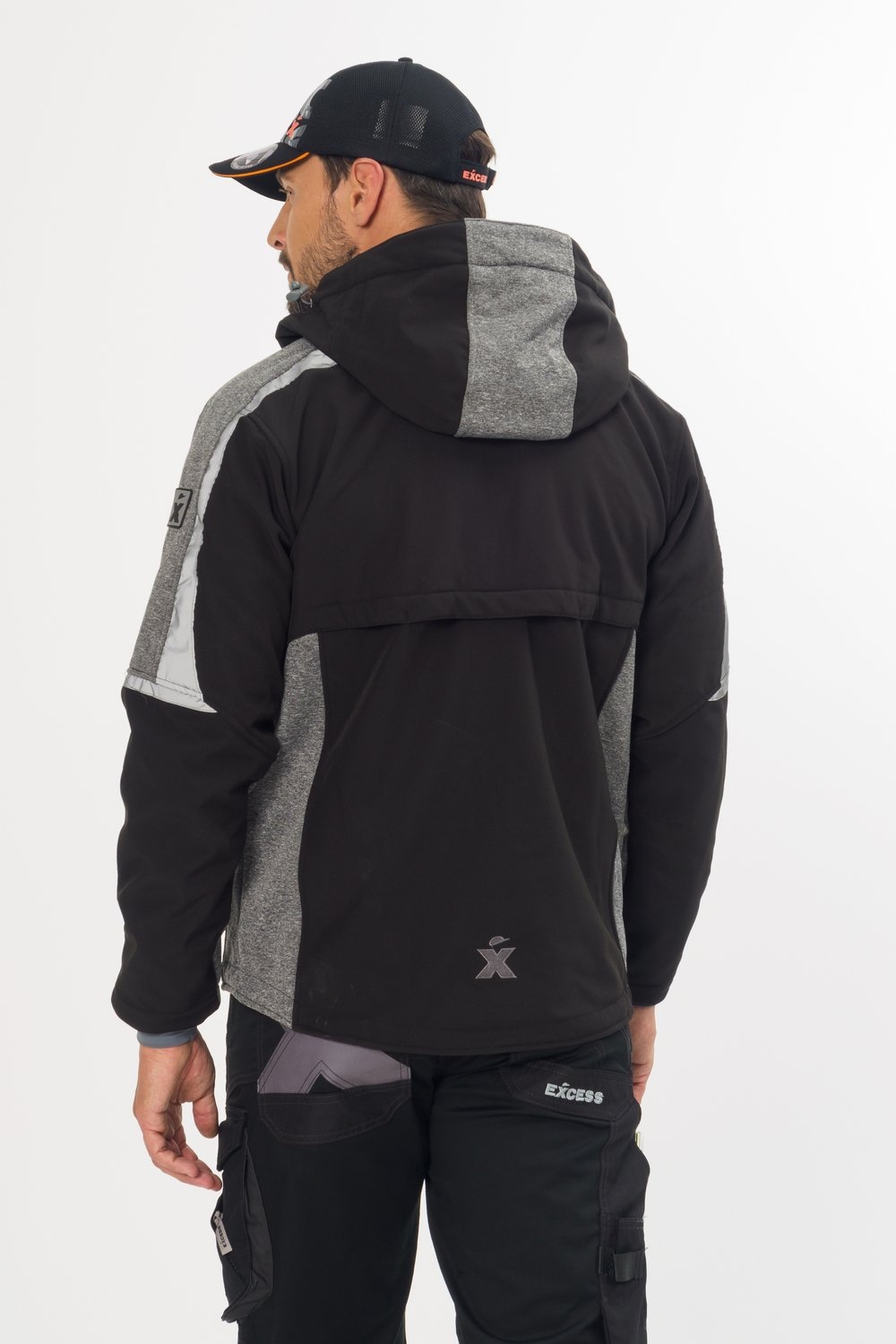 Excess Workwear Softshelljacke in Schwarz mit grauen Einsätzen, Rückansicht mit Kapuze und Logo, atmungsaktiv und modern.