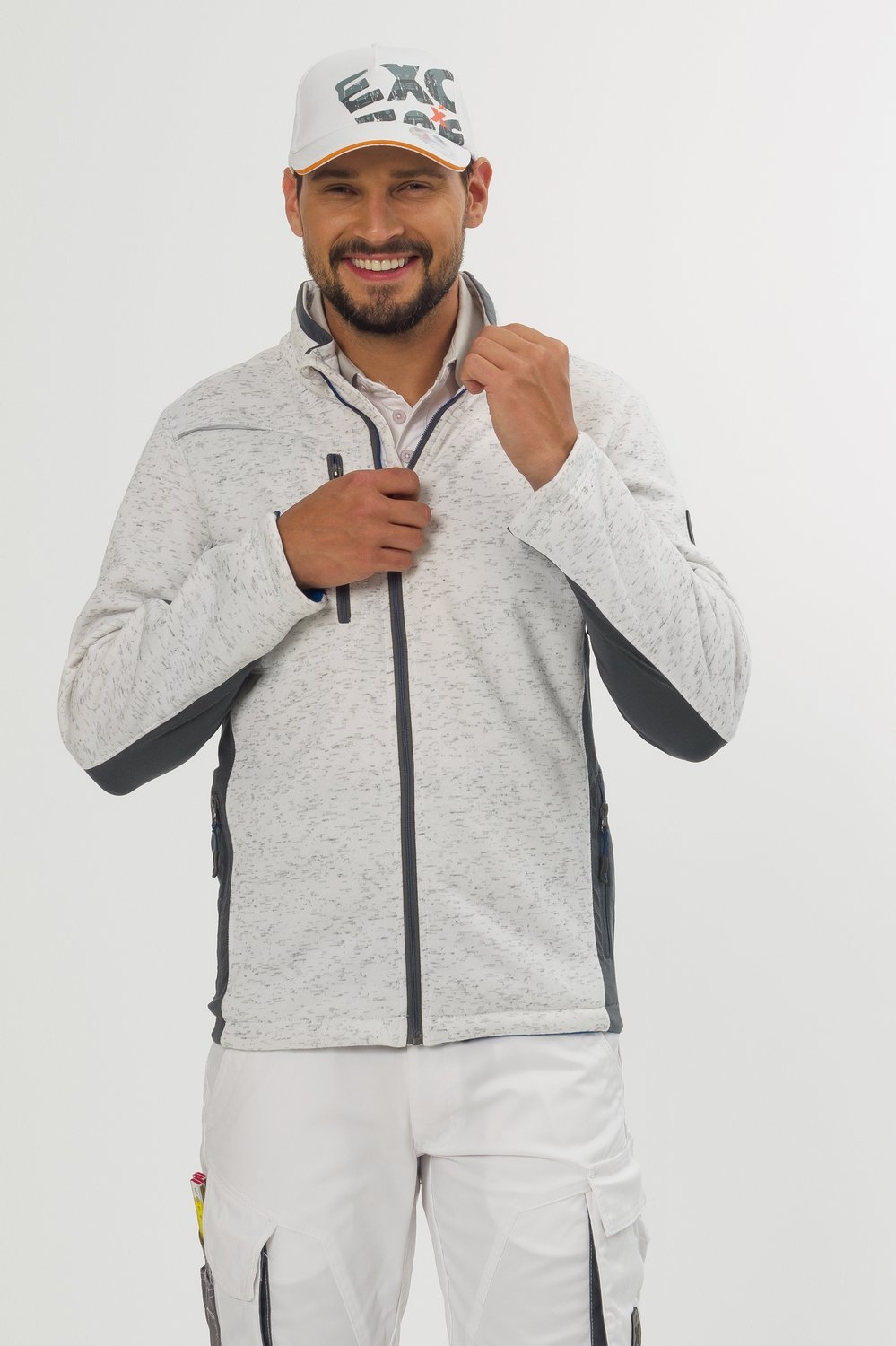 Weiß-melierte Sweatjacke mit Reißverschluss – moderne Arbeitskleidung von EXCESS, getragen von Mann mit weißer Hose und passender Cap.