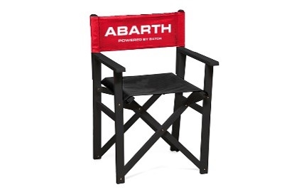Schwarzer Klappstuhl mit Armlehnen, schwarzer Sitzfläche und roter Rückenlehne mit weißem Abarth-Schriftzug.