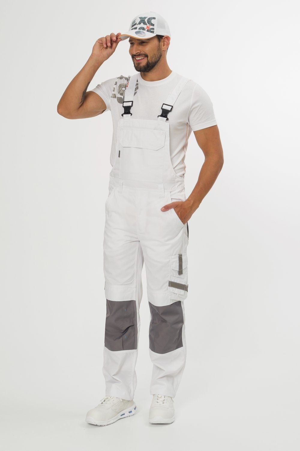 Weiße Latzhose mit grauen Knieverstärkungen und vielen Taschen – strapazierfähige Arbeitslatzhose für Handwerker und Bau.